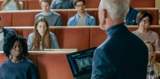 a lecturer giving class using a laptop