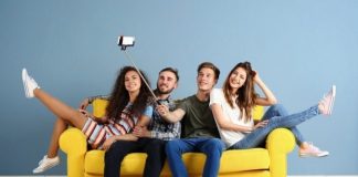 Friends sitting on a yellow couch taking a selfie