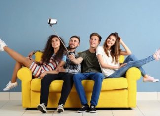 Friends sitting on a yellow couch taking a selfie
