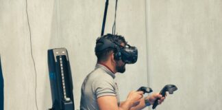 man in gray t-shirt and black pants holding black dslr camera