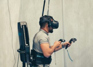 man in gray t-shirt and black pants holding black dslr camera