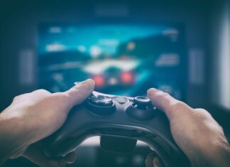 A picture containing person, holding, remote, indoor Description automatically generated