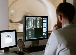 5 Areas of Healthcare Affected by Technological Advancements A person looking at a computer screen Description automatically generated with medium confidence