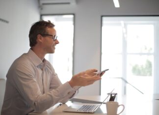 5 Reasons Why You Need Modern Business Reports Smiling adult businessman at table with gadgets holding presentation