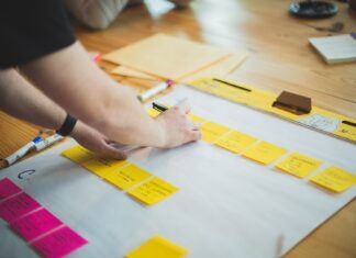 8 Ways to Ensure Timely Project Completion in Construction person writing on white paper