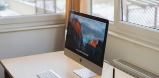 turned on silver iMac on table