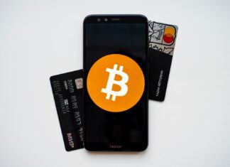 Booking traveling trips by using Bitcoin black android smartphone on white surface
