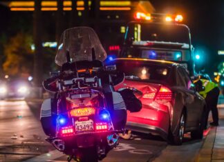 Top Qualities To Look For In A Car Accident Lawyer policeman leaning on sports car's window