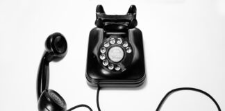 black rotary dial phone on white surface
