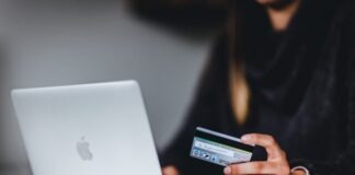 woman holding black smartphone near silver macbook