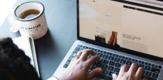 person using macbook pro on black table