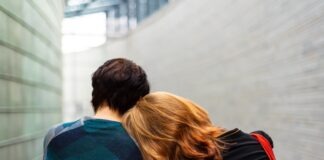 a woman rests her head on another person's shoulder