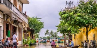 two women riding boat beside brown house