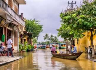 If Your Business Floods Here’s What to Do two women riding boat beside brown house