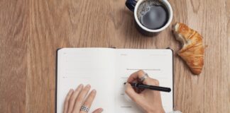 person writing on a book