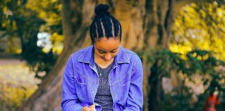 selective focus photography of woman reading book while sitting at bench