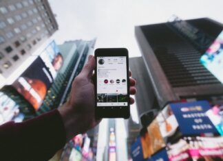 5 amazing tips to gain traffic from instagram high angle photo of person holding turned on smartphone with tall buildings background