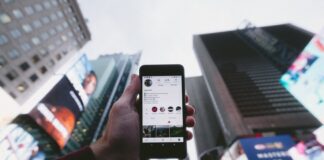 high angle photo of person holding turned on smartphone with tall buildings background