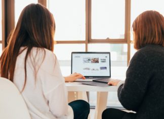 How to Handle Disagreements Within the Management Team two women talking while looking at laptop computer