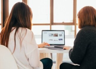 10 Advantages of Using Employee Time Tracking Software for Your Business two women talking while looking at laptop computer