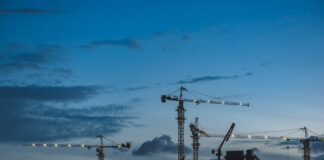 several cranes above the buildings