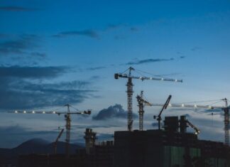 8 Strategies for Construction Cost Tracking several cranes above the buildings
