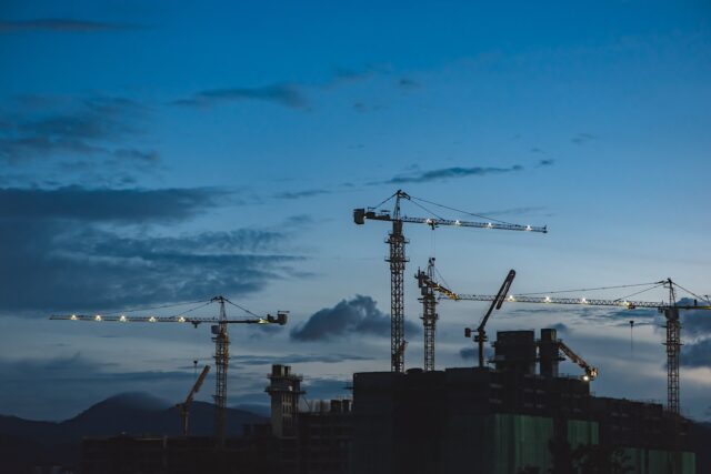 Photo by EJ Yao several cranes above the buildings