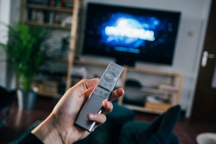 Photo by Jonas Leupe person holding gray remote control