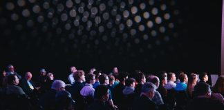 crowd of people sitting on chairs inside room