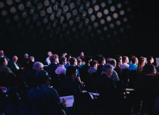 crowd of people sitting on chairs inside room