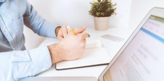 person writing on white notebook