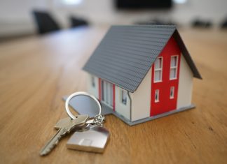 How To Tell If You’re Overpaying For Your Homeowners Insurance white and red wooden house miniature on brown table