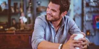 man holding cup on table