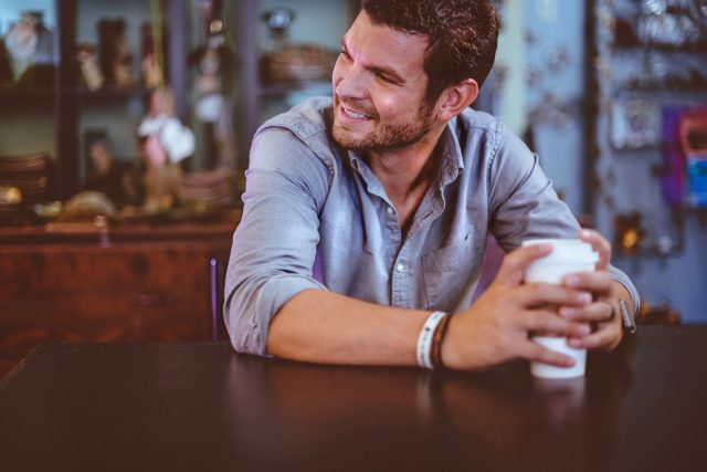 Photo by Ben White man holding cup on table