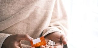 orange and white plastic bottle on white textile