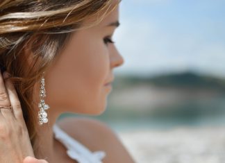 How to Choose the Right Moissanite Earrings – The Ultimate Guide shallow focus photography of woman wearing dangling earrings holding her hair near mountain