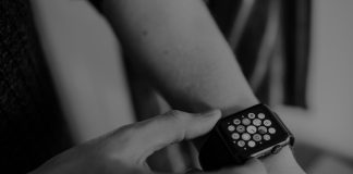 grayscale photo of person using Apple Watch