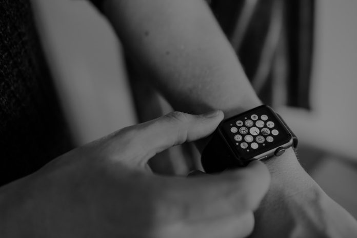Photo by Miss Zhang grayscale photo of person using Apple Watch