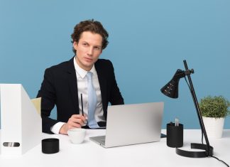 Are You Ready to Be an Interim Manager? man sitting on chair beside laptop computer and teacup
