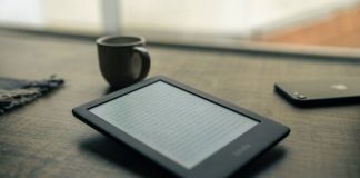 black android smartphone beside black ceramic mug on brown wooden table