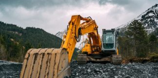 yellow and black excavator on rocky ground