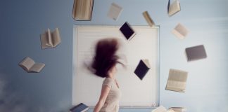 woman sitting on bed with flying books