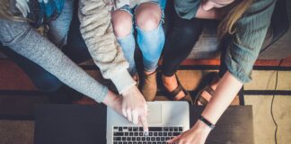 three person pointing the silver laptop computer