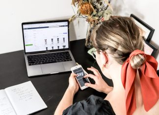 3 Steps To Launching Your Ecommerce Business woman in orange shirt using iphone