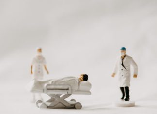 man in white coat and black pants standing beside white wooden picnic table