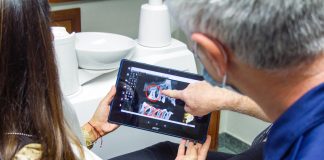 woman in blue denim jeans holding black tablet computer