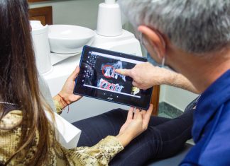 Dental Software Trends woman in blue denim jeans holding black tablet computer