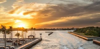 people sailing on river near parking lot