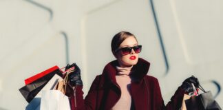 photo of woman holding white and black paper bags