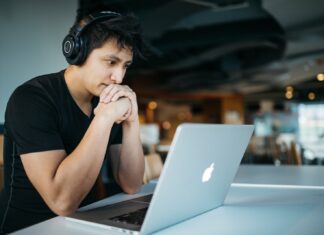 How Adults Can Benefit From Online Learning man wearing headphones while sitting on chair in front of MacBook